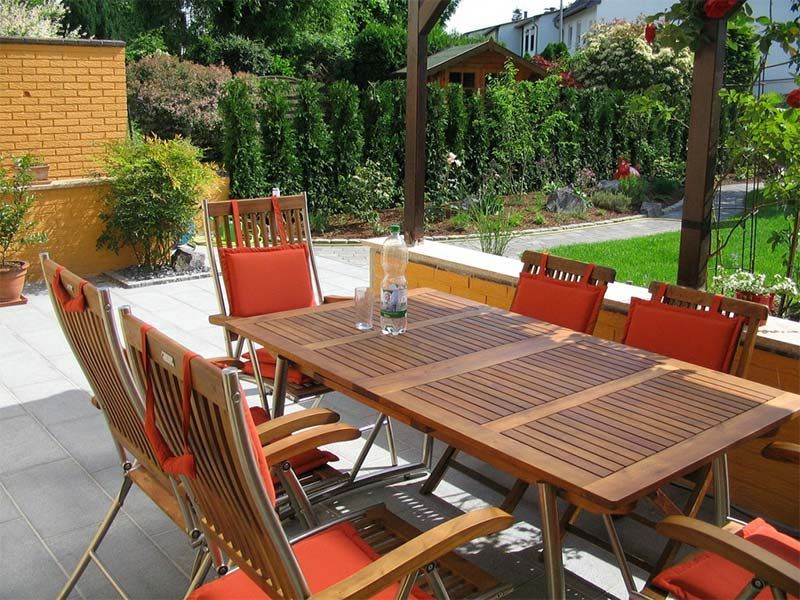 Ein Tisch und Stühle auf einer Terrasse mit einer Flasche Wasser darauf
