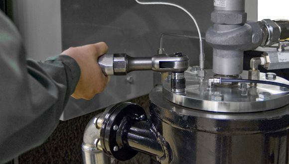 Technicien utilisant une clé sur un compresseur