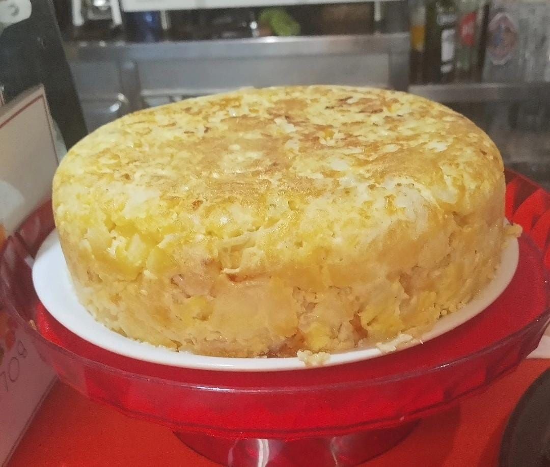 Una tortilla grande está encima de un plato rojo.