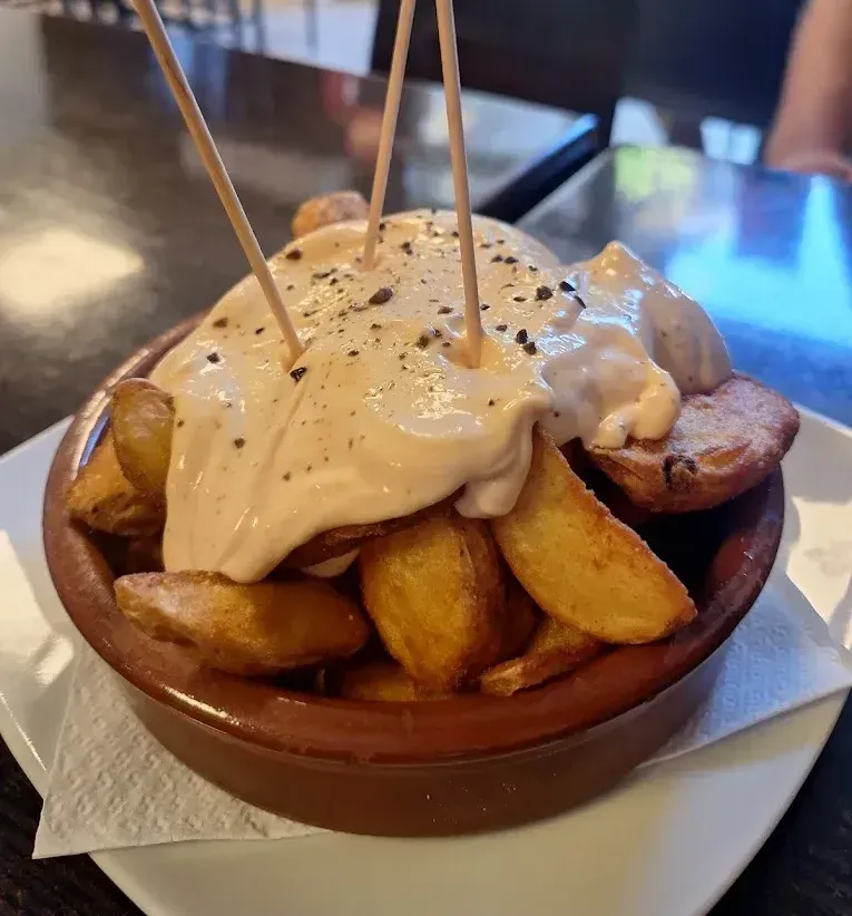 Un tazón de papas fritas con palillos dentro
