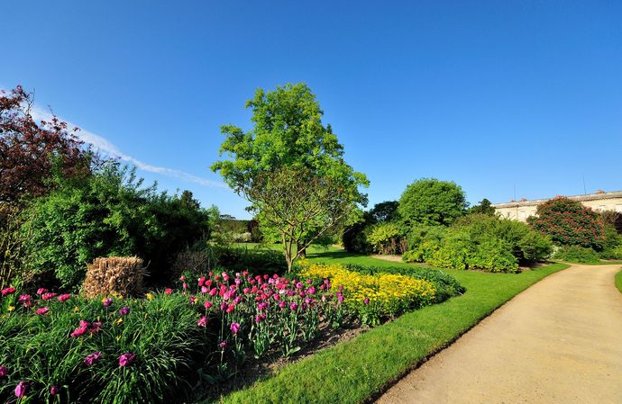 Un parc paysagé avec massif de fleurs.