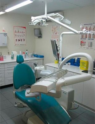 Un consultorio dental con un sillón dental y un monitor