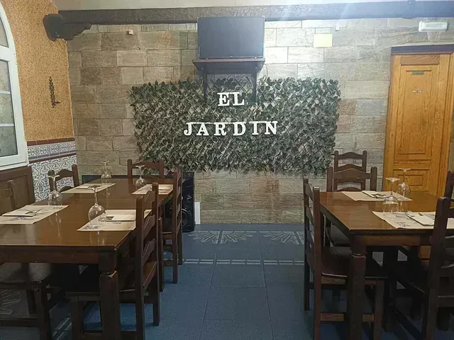 Interior de restaurante con mesas y sillas de madera. El letrero