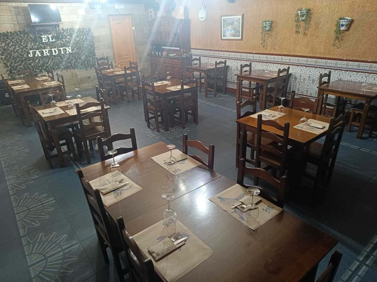 Interior de restaurante con mesas y sillas de madera. Letrero 