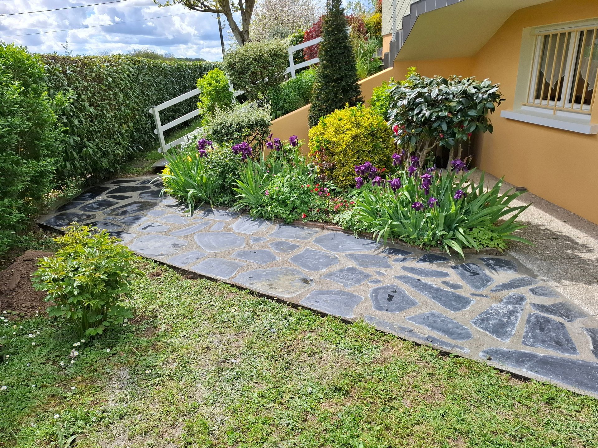 Un chemin de pierre serpente à travers un jardin.