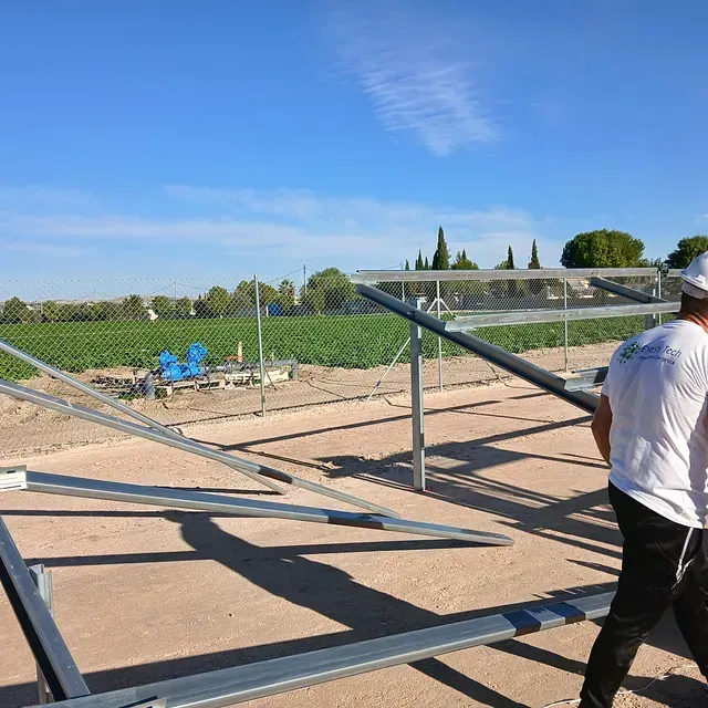 Un hombre con camisa blanca está trabajando en una estructura metálica.