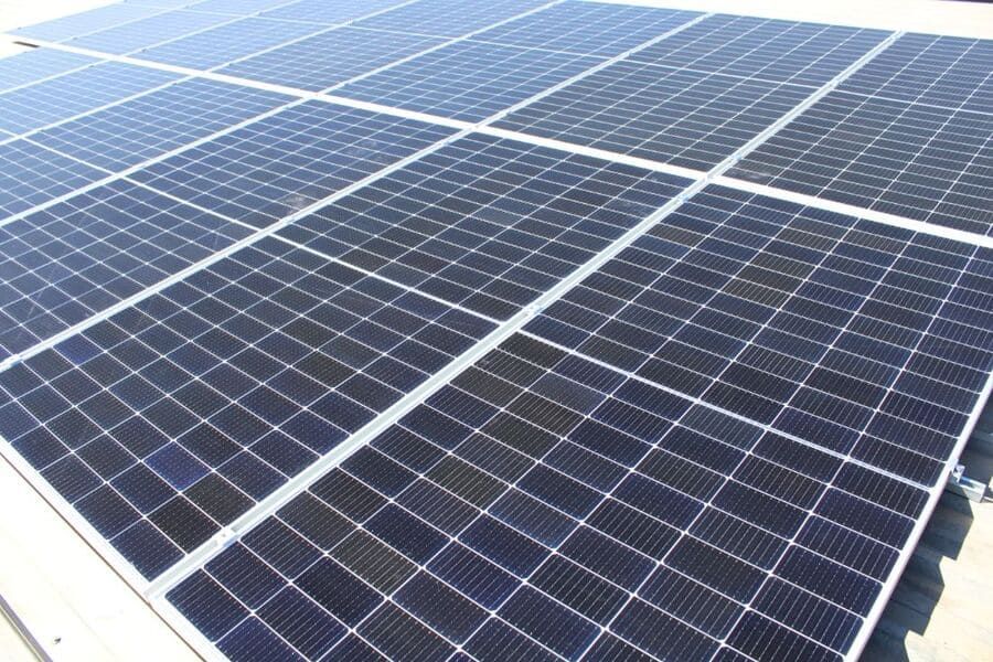 Una fila de paneles solares están colocados encima de un tejado.