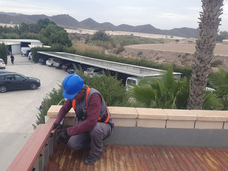 Un hombre que lleva un casco azul está trabajando en una cubierta.