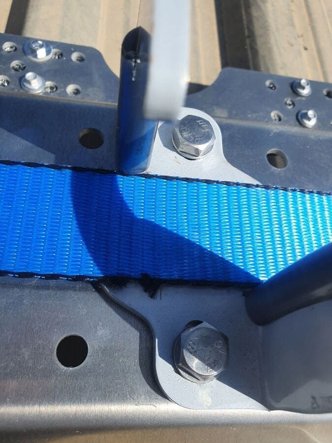 Una correa azul está unida a un marco de metal.