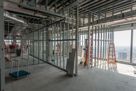 Un grand bâtiment en construction avec beaucoup de fenêtres et une échelle.