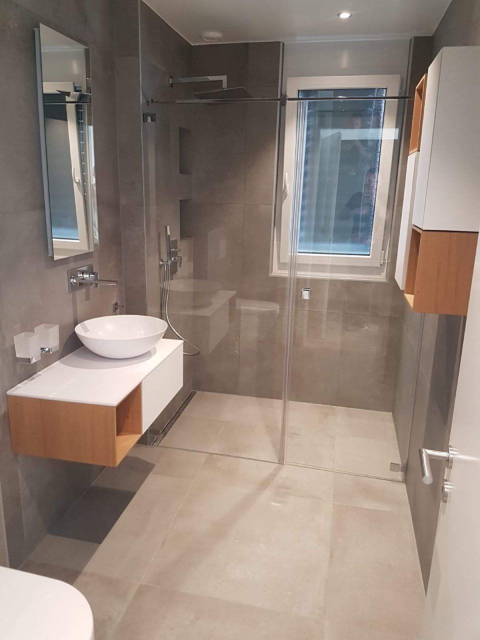 Une salle de bain avec lavabo, WC et douche à l'italienne.