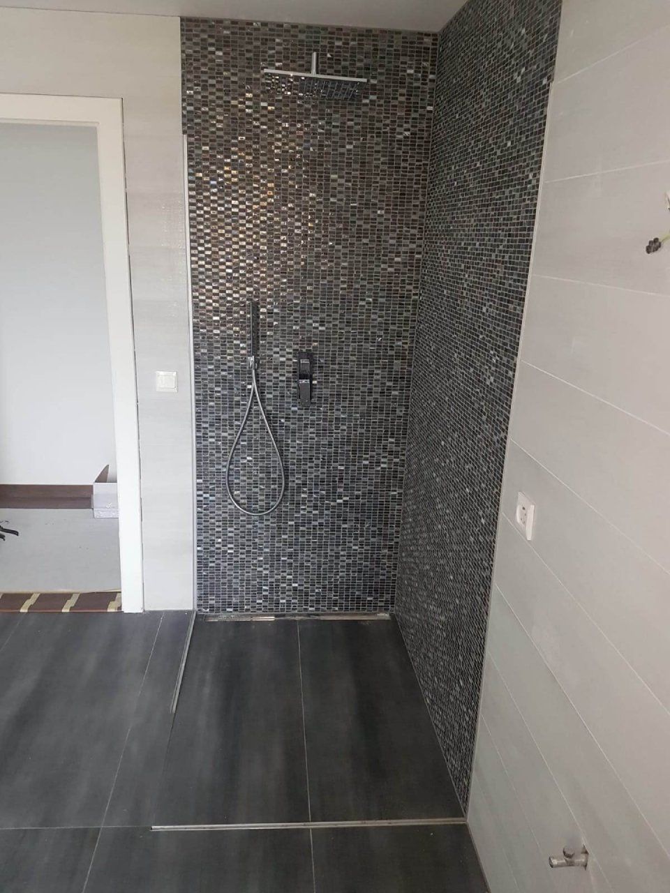 Une salle de bain avec une douche à l'italienne et une porte.
