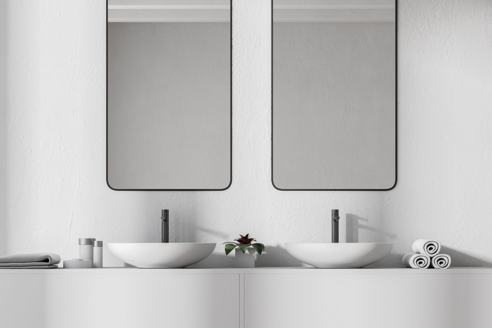 Baño blanco con dos lavabos, espejos y toallas.