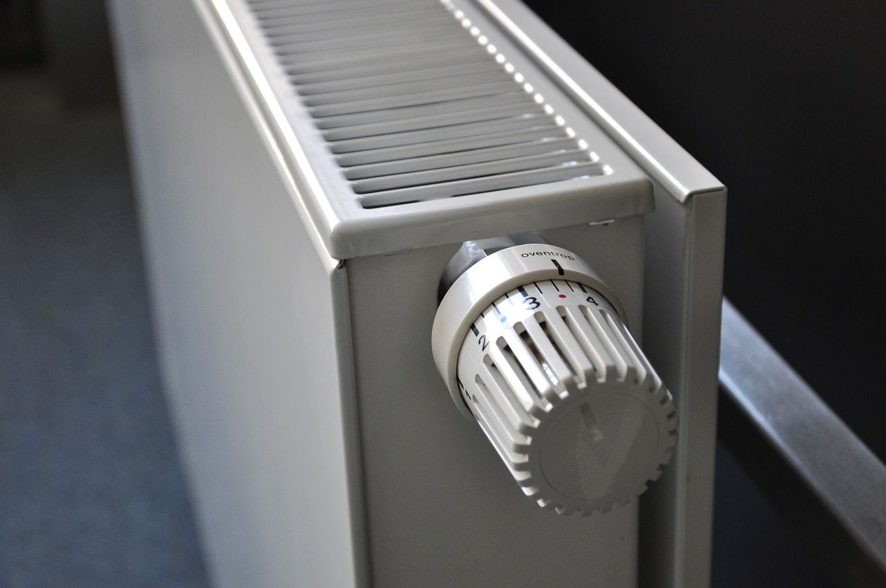 Radiador blanco con dial de control del termostato.