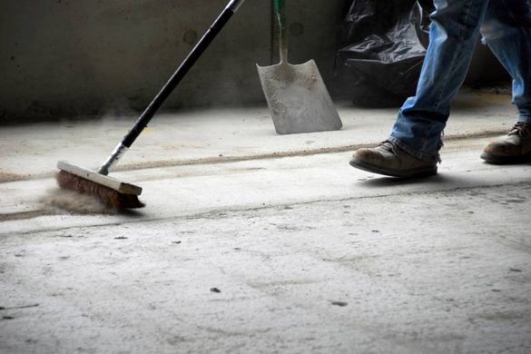 Mitarbeiter von Badalli Bauservice reinigt Boden