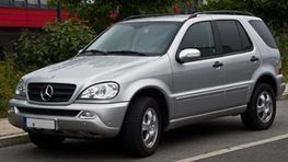 Un SUV Mercedes plateado aparcado en la calle.