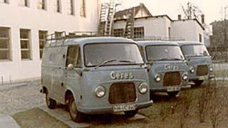 Drei hellblaue Lieferwagen parken vor einem Gebäude. Auf der Vorderseite der Lieferwagen steht „Ceres“.