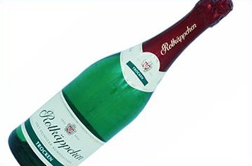 Flasche Rotkäppchen Trocken Sekt, grünes Glas mit rotem Folienverschluss und weißem Etikett.