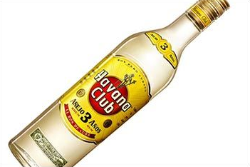 Flasche Havana Club Añejo 3 Años Rum, Klarglas mit gelbem Etikett und goldenen Akzenten, leicht schräg.