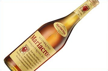 Flasche der Marke Mariacron, schräg vor weißem Hintergrund; Etikett mit rotem Emblem und goldenen Akzenten.