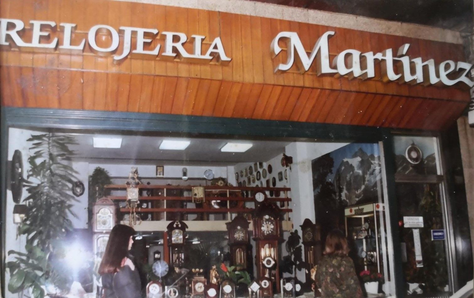 Una mujer parada frente a una tienda llamada Relojería Martínez.