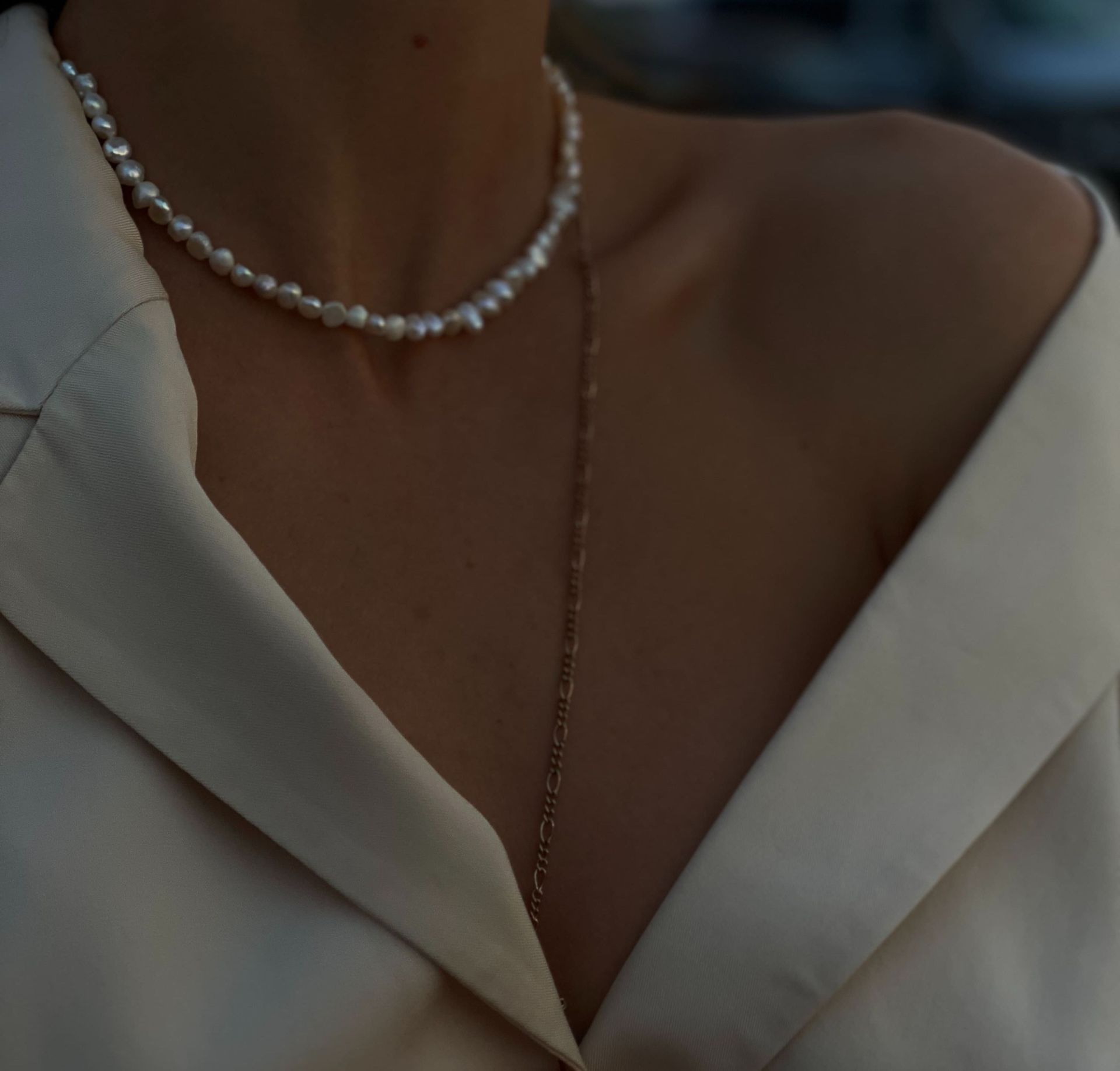 Un primer plano de una mujer que lleva un collar de perlas.