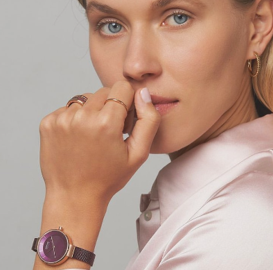Una mujer que lleva un reloj y un anillo en el dedo.