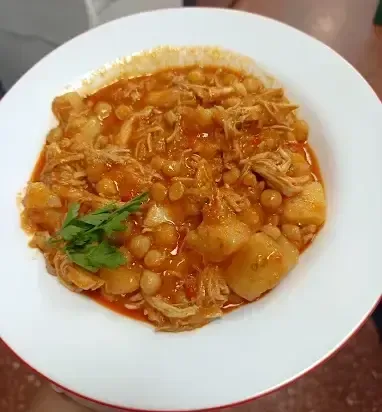 Un bol de estofado de garbanzos y carne desmenuzada con trozos de patata