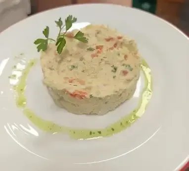 Un cilindro de ensalada de patata con verduras cortadas en dados