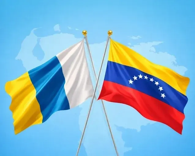 Dos banderas cruzadas: una amarilla, azul y blanca junto a la bandera venezolana sobre un fondo de mapa azul claro.