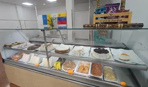 Una vitrina repleta de comida, platos variados, con pequeñas decoraciones de frutas en los estantes.
