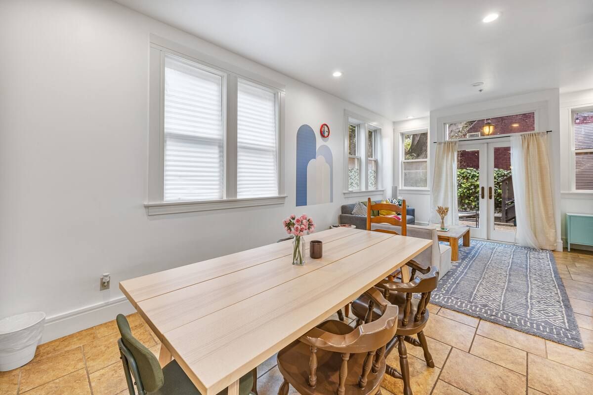A dining room with a wooden table and chairs in a house.