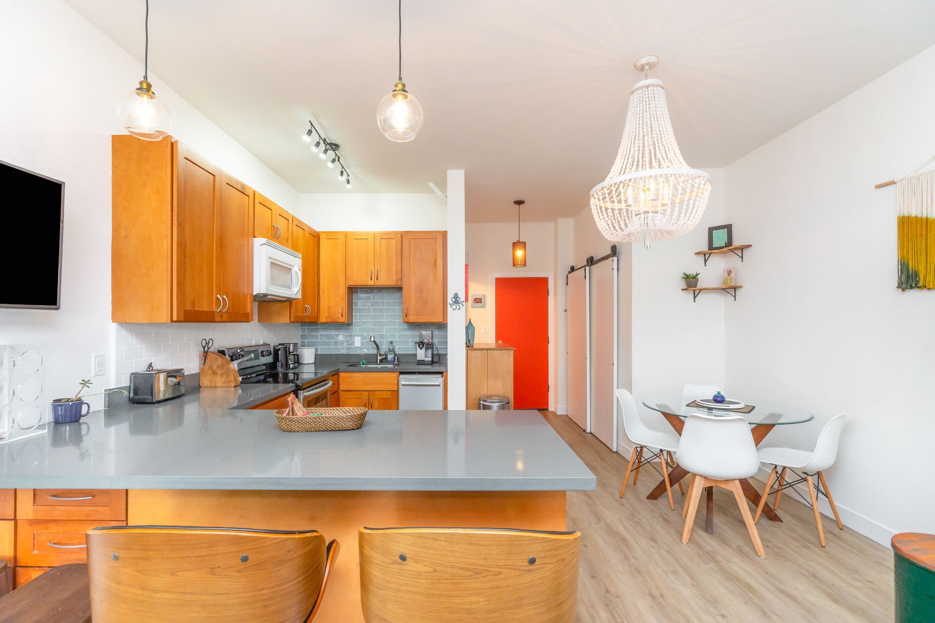 A kitchen with a dining table and chairs and a chandelier hanging from the ceiling.