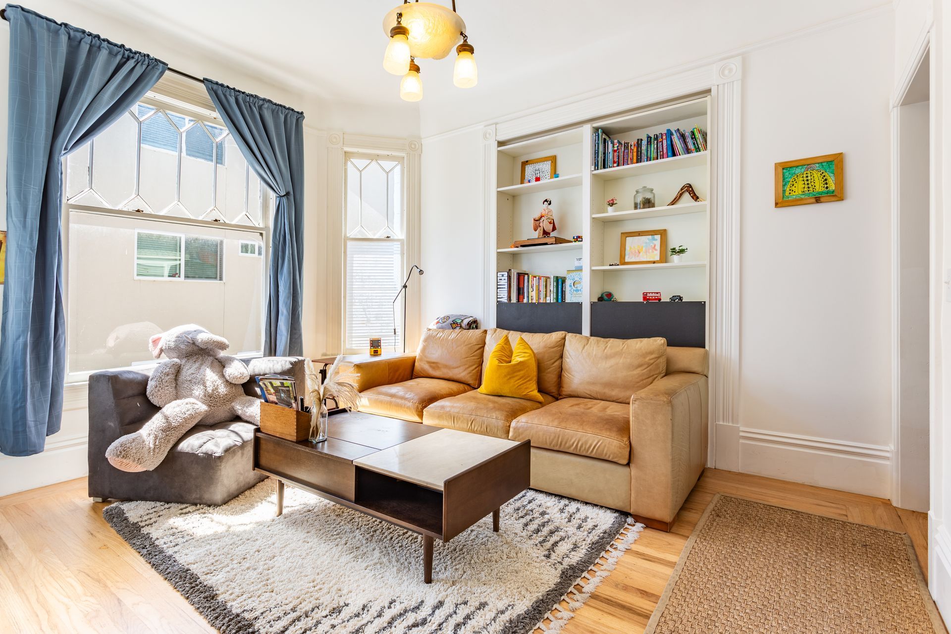There is a teddy bear on the couch in the living room.