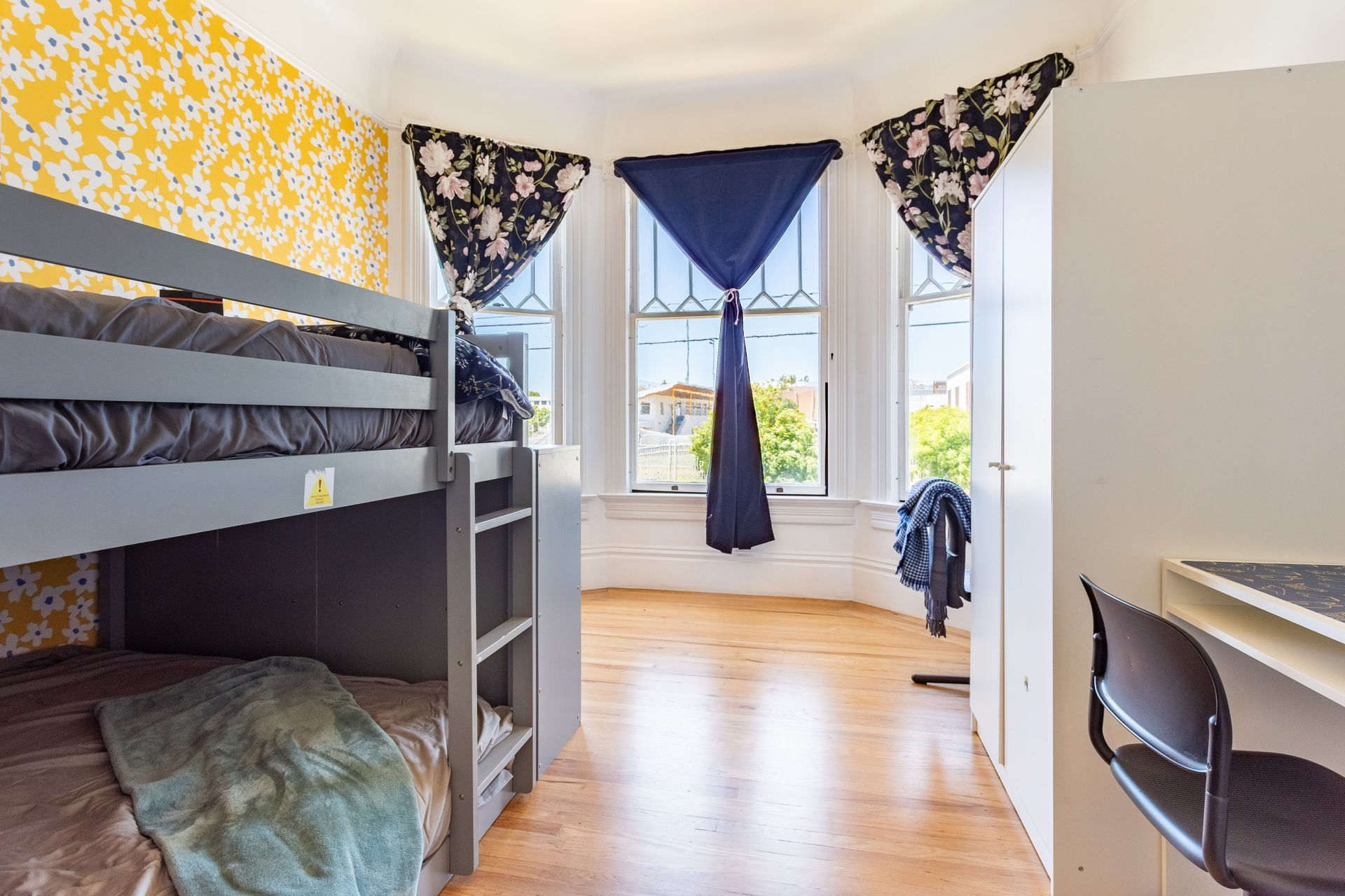 A bedroom with bunk beds , a desk and a chair.
