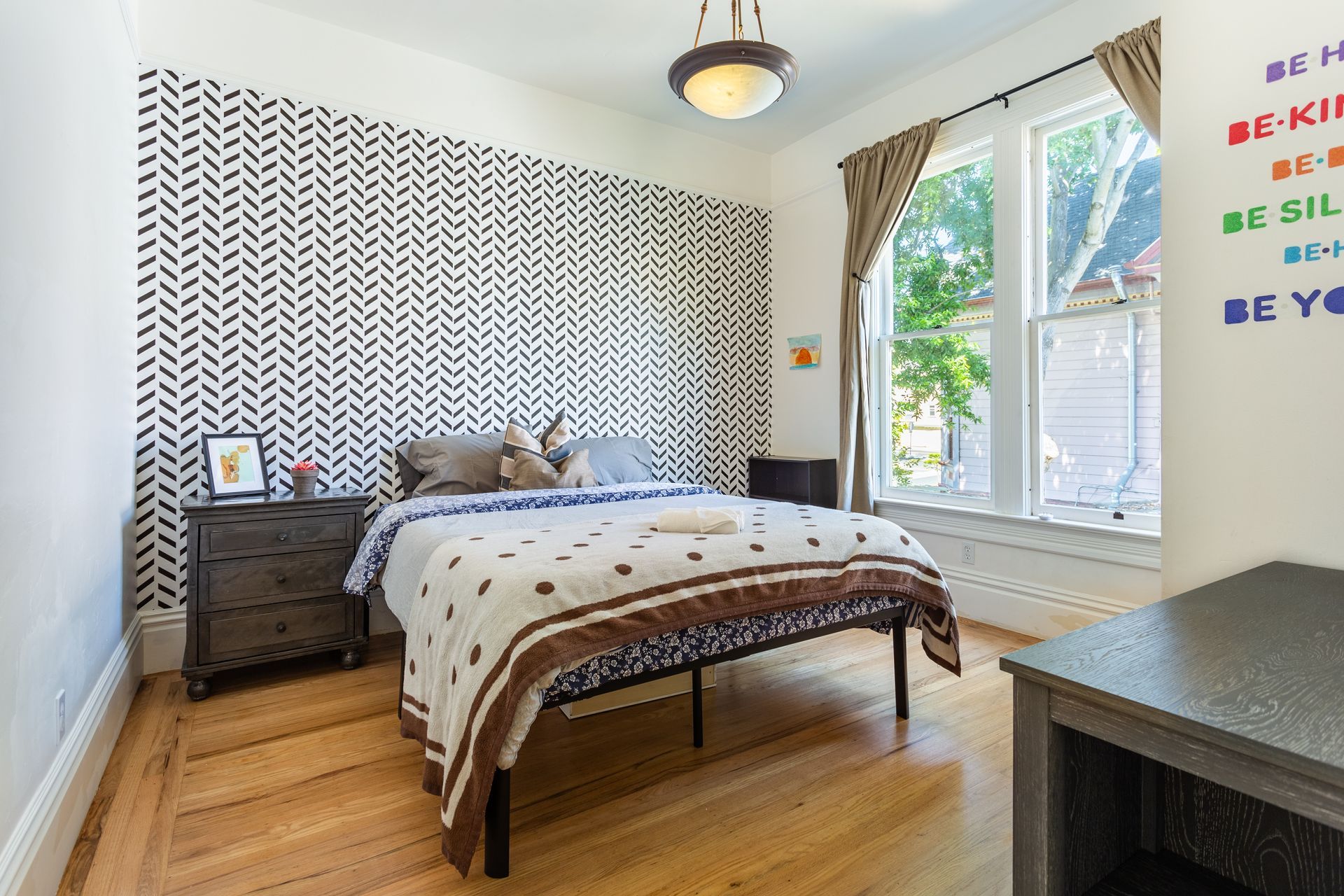 A bedroom with a bed , nightstand , and window.