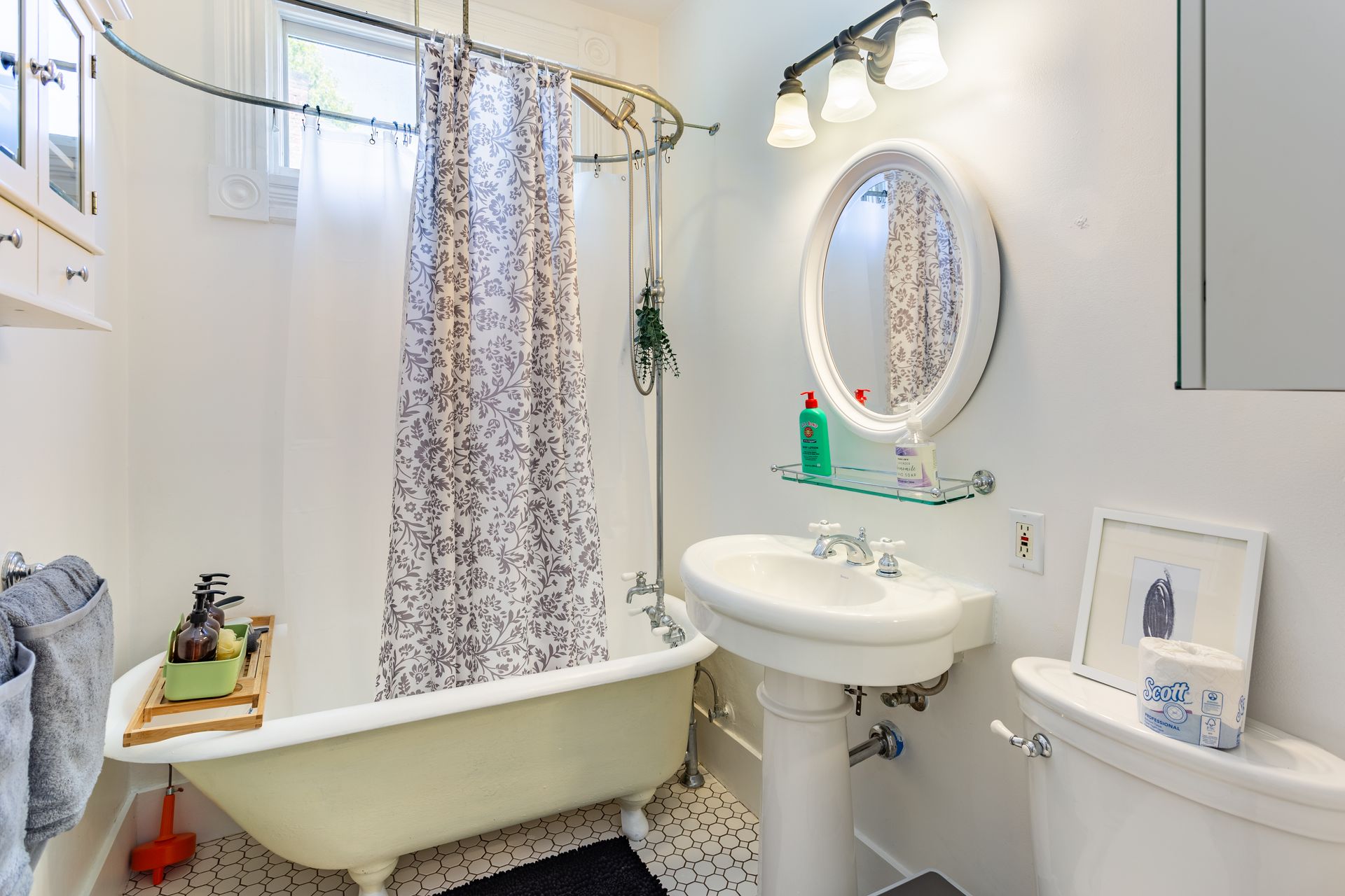 A bathroom with a bathtub , sink , toilet and mirror.