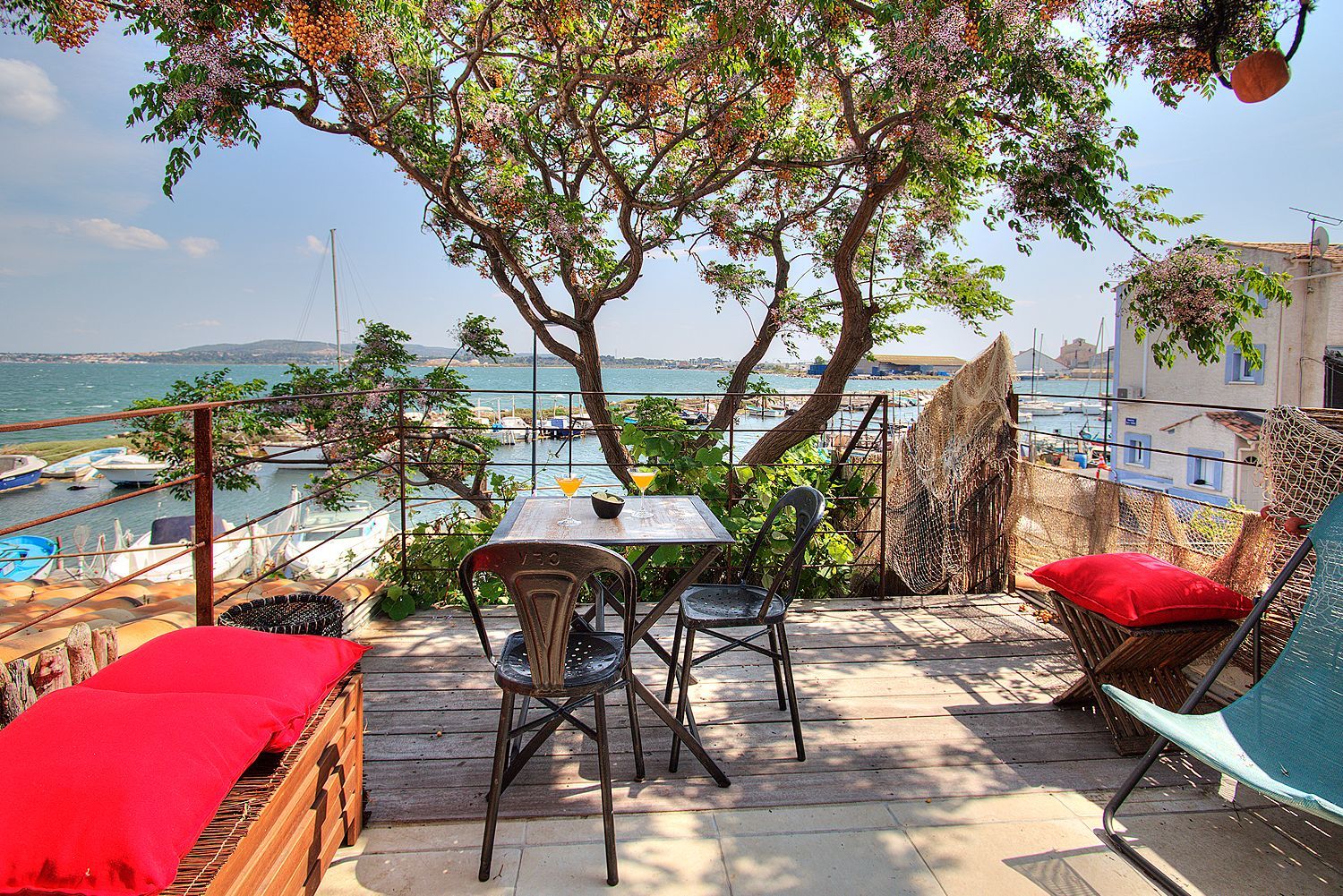 Terrasse ombragée avec table de jardin et vue sur la lagune