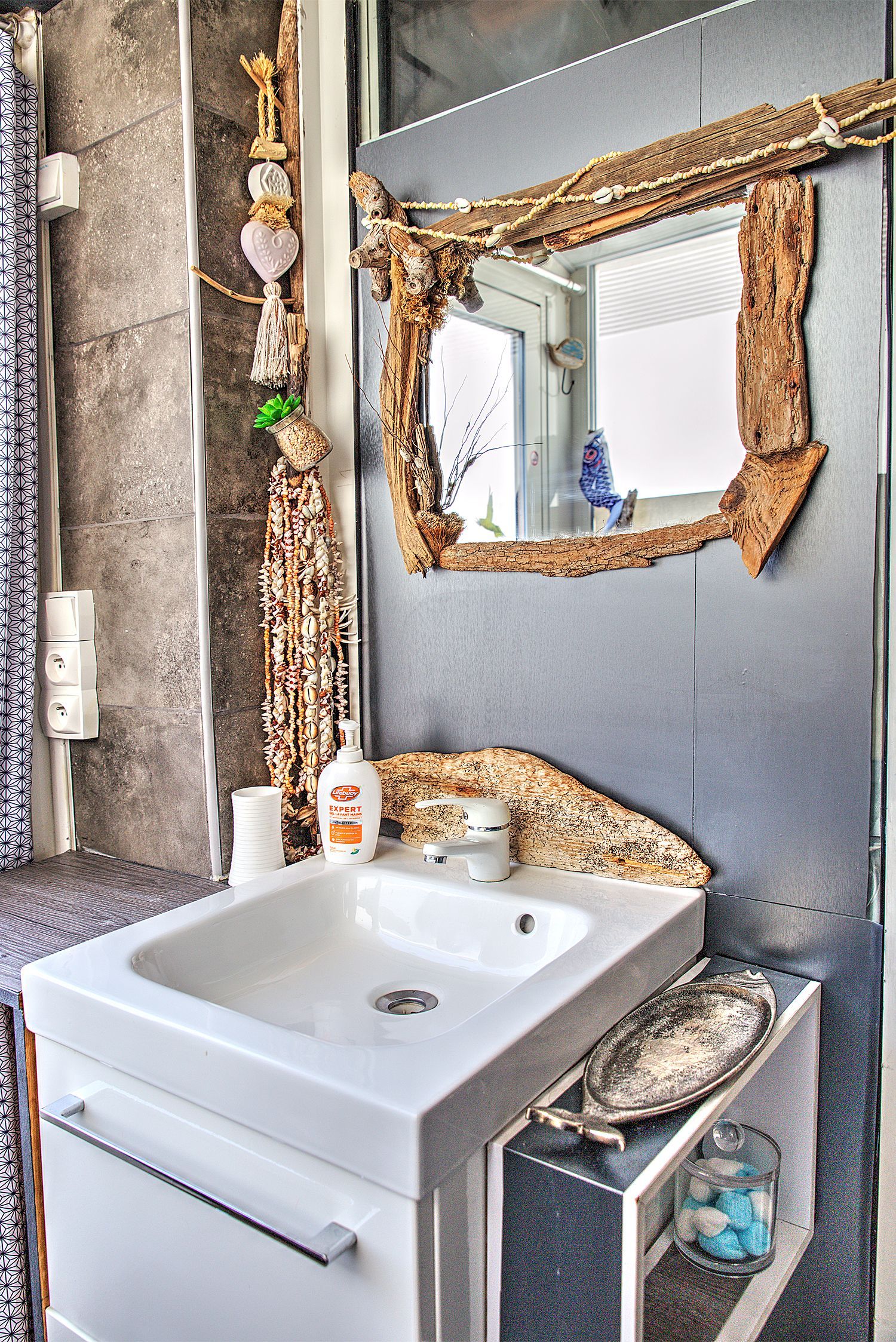 Lavabo de salle de bains avec miroir décoré de bois flotté