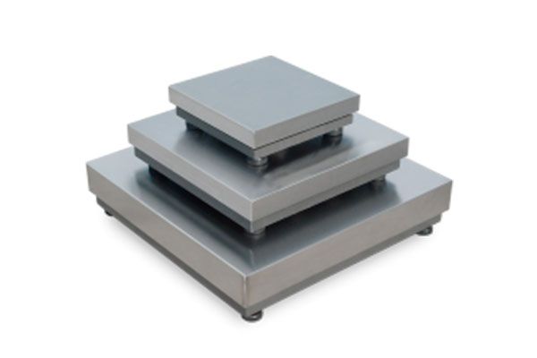 Tres placas de acero inoxidable están apiladas una encima de otra sobre un fondo blanco.