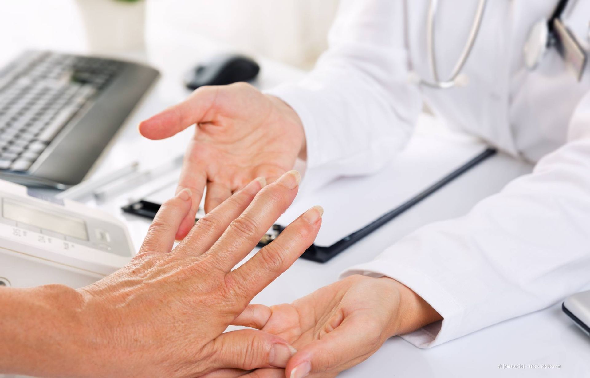 Ein Arzt untersucht die Hand des Patienten auf mögliche Gelenkprobleme.