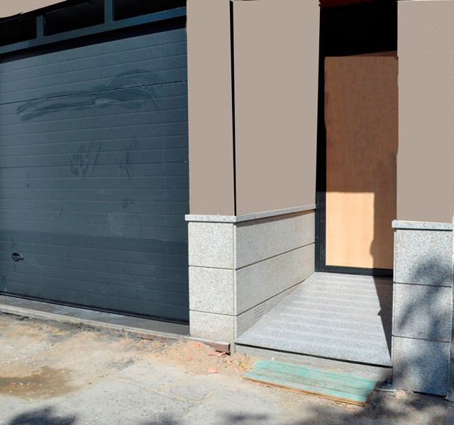 Un edificio con una puerta de garaje y una entrada