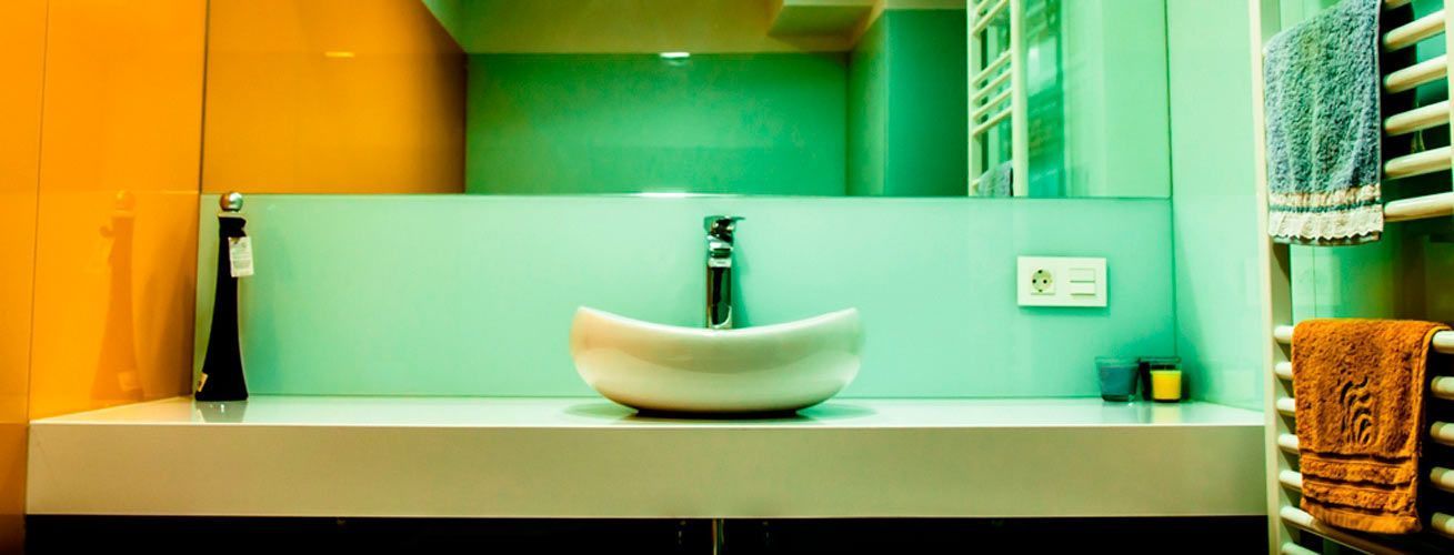 Un baño con lavabo, espejo y toallero.