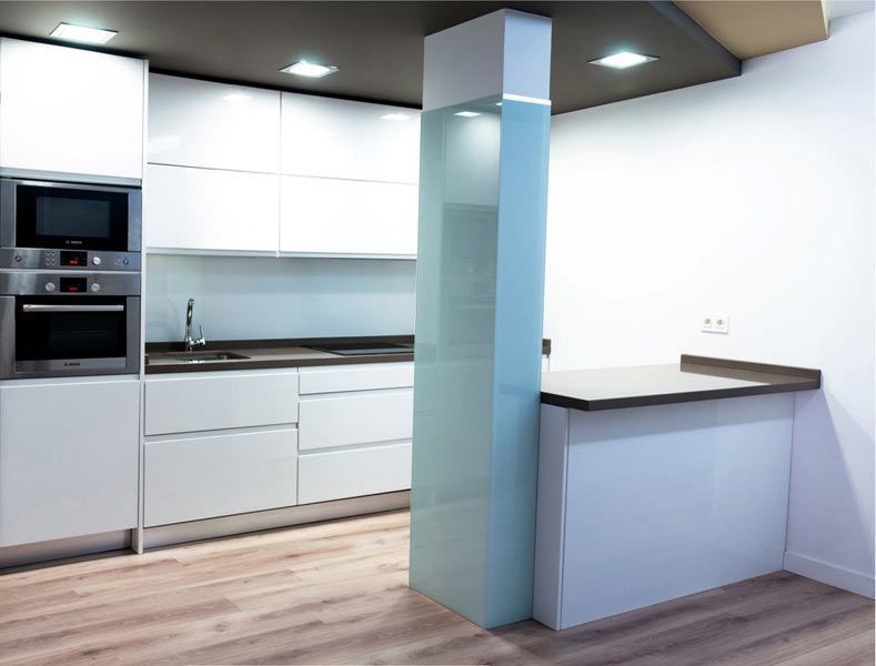 Una cocina con gabinetes blancos y electrodomésticos de acero inoxidable.