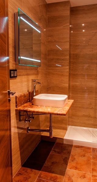 Un baño con lavabo, espejo y ducha.