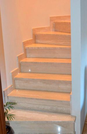 Un conjunto de escaleras de mármol que conducen al segundo piso de una casa.