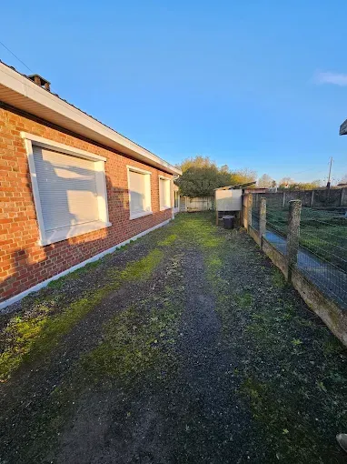 Une maison en briques avec une clôture en bois devant.