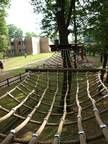Ein Hochseilgarten in einem Park mit Bäumen im Hintergrund.