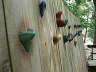 Ein Holzzaun mit daran befestigten Klettergriffen.