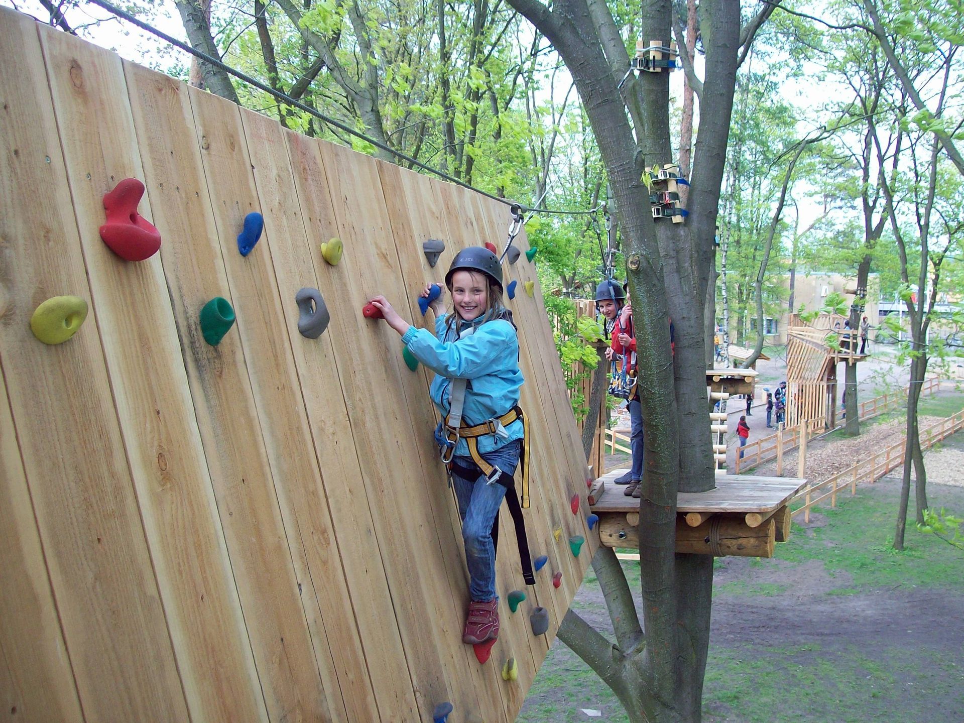 Ein junges Mädchen klettert eine Holzwand hoch